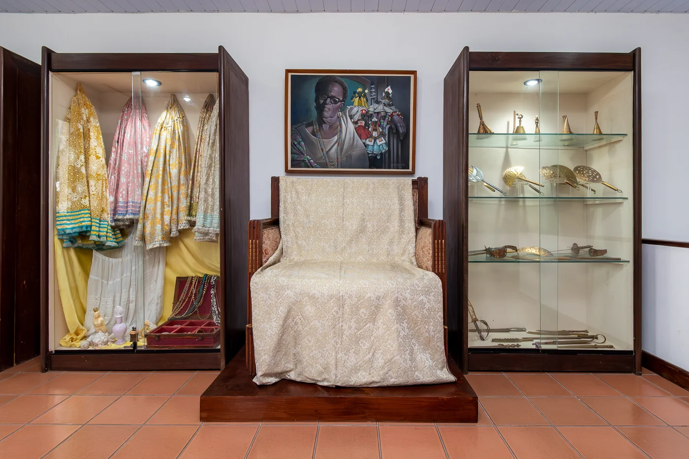 Trono usado por Mãe Menininha do Gantois em madeira e pintura a ouro recoberto por um Alaká (Pano da Costa) Tela de Carlos Bastos